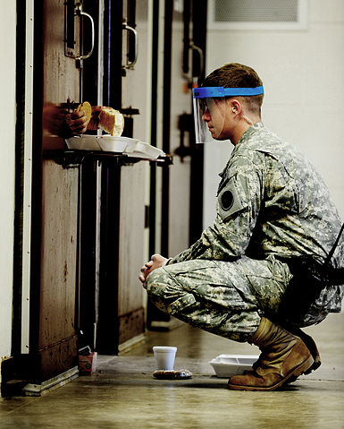 Guard delivers meal to solitary prisoner